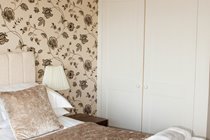 Top main bedroom with TV and built in wardrobe.