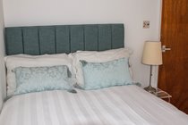 Smaller top floor back bedroom. Small double bed, comfortable size for a single adult. Hooks and chest of drawers rather than wardrobe and a TV to keep you entertained.