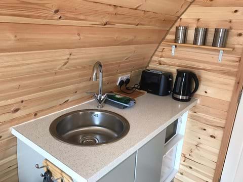 Kitchenette with small fridge, electric induction hob, microwave, toaster, kettle, complimentary tea, coffee, sugar, washing up liquid, J-cloth & T-towel.
