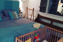 Wooden cot and bedding provided for babies at Chapel Bay Lodge