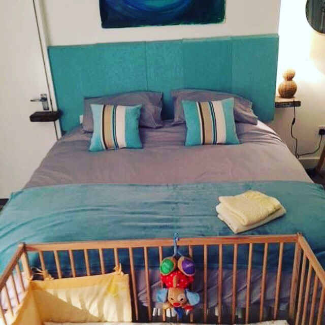 Wooden cot and bedding provided for babies at Chapel Bay Lodge