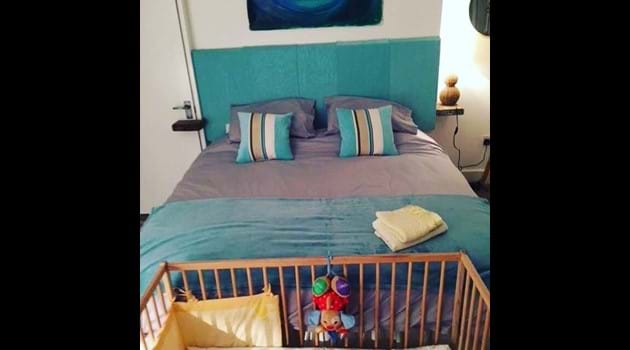 Wooden cot and bedding provided for babies at Chapel Bay Lodge