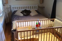 Wooden cot and bedding provided for babies at Bishop