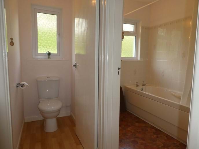 Bathroom with overhead shower and separate toilet