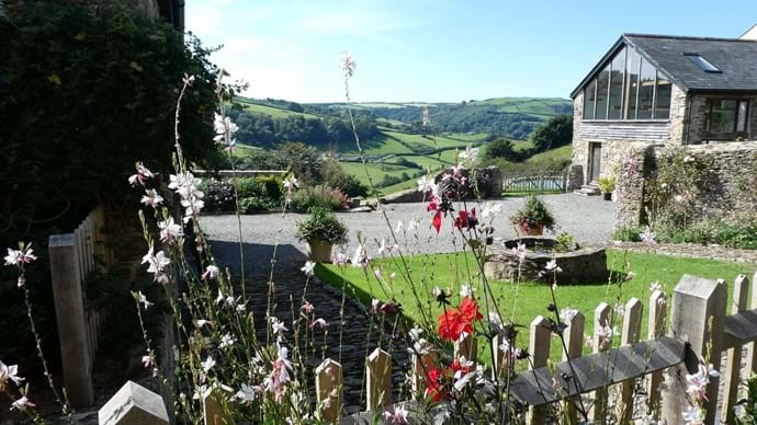 View across the garden to the countryside beyond from Nutcombe Barn terrace