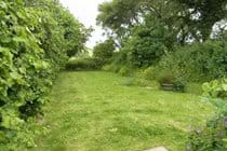The cottage has two gardens and wooden picnic benches