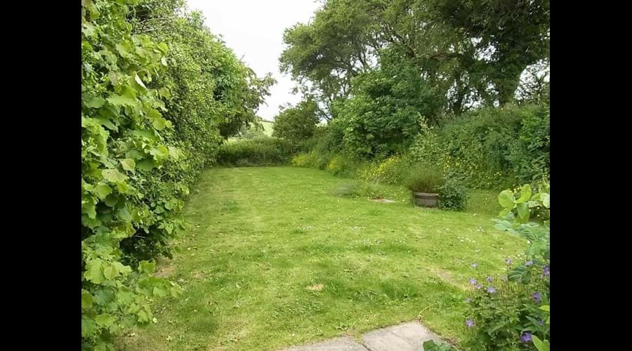 The cottage has two gardens and wooden picnic benches