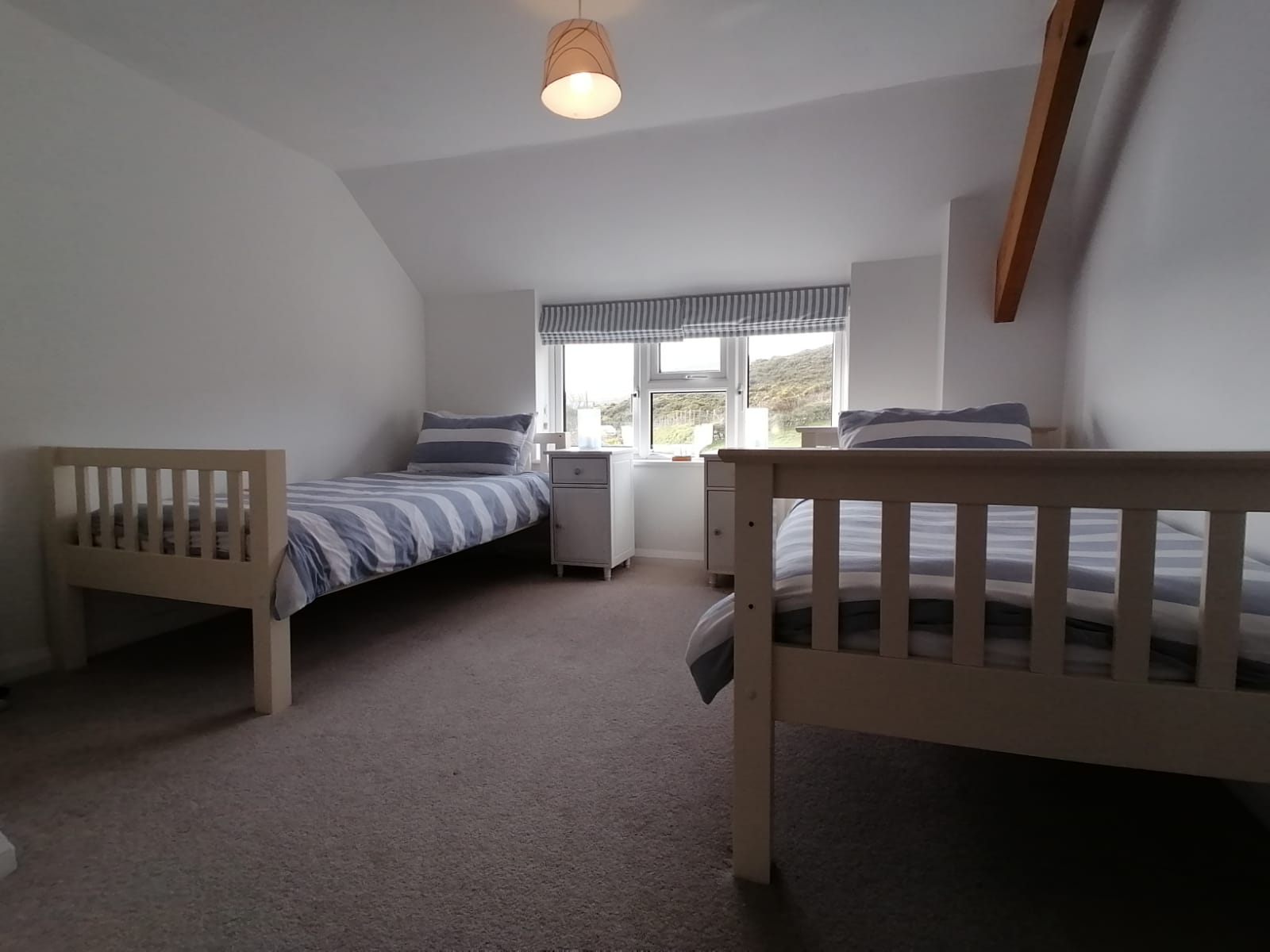 Twin bedded room with large  wardrobe, bedside tables and sea views