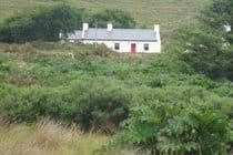 View of the cottage from the bridge over the river (Road)