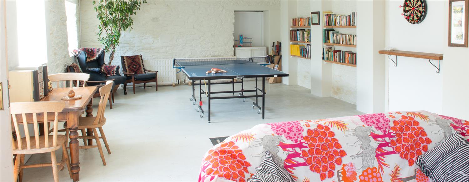 view of table tennis table and darts board from sofa end of Games Room