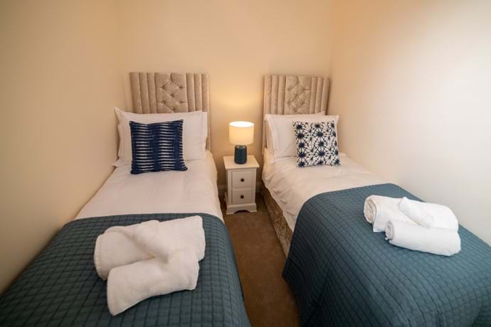 Twin beds with luxury bed linen and towels.