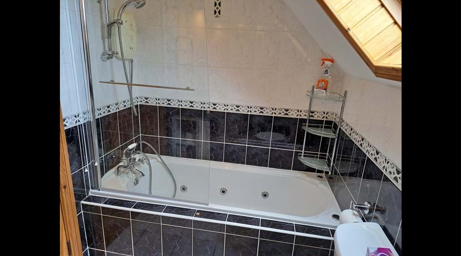 The jacuzzi bath with shower over in the family bathroom