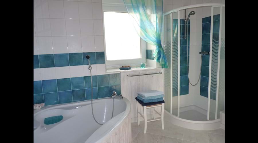 Bathroom with separate shower cubicle and bath with overhead shower