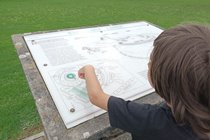a boy points to the information display for Barnstaple Castle