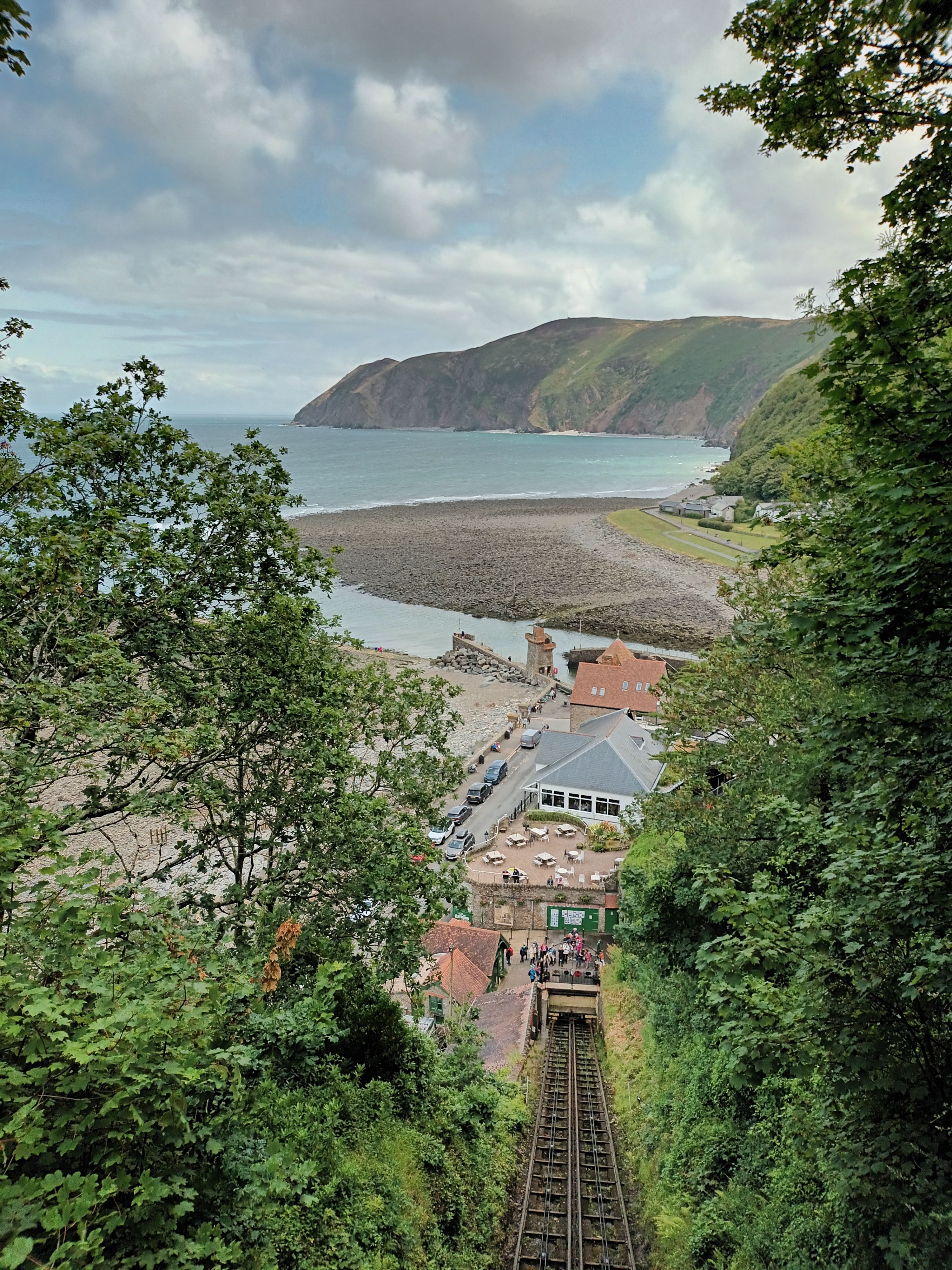 View of the tree lined cliff railway with the bay and cliffs in the distance