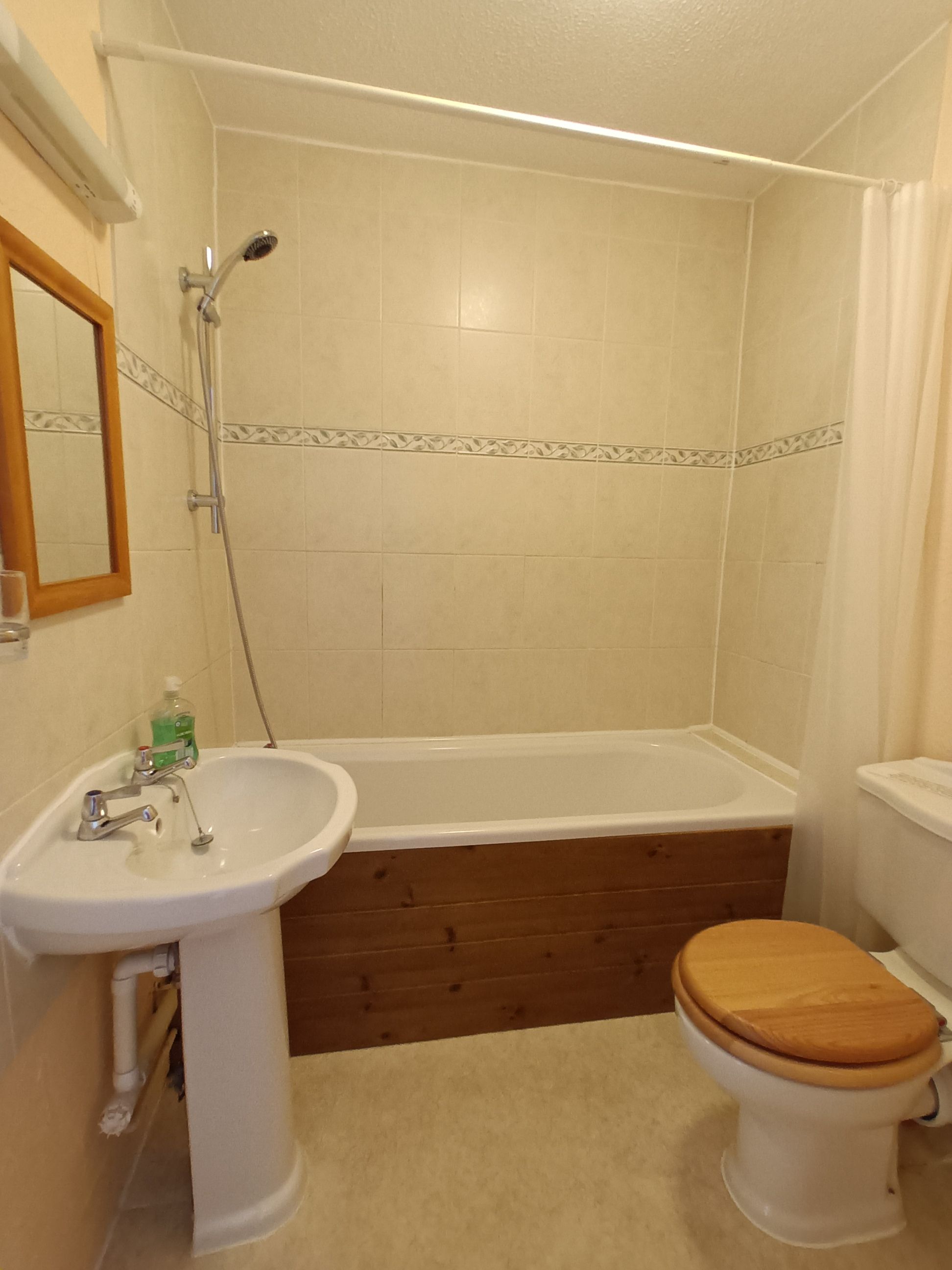 The ground floor ensuite has a bath with shower over