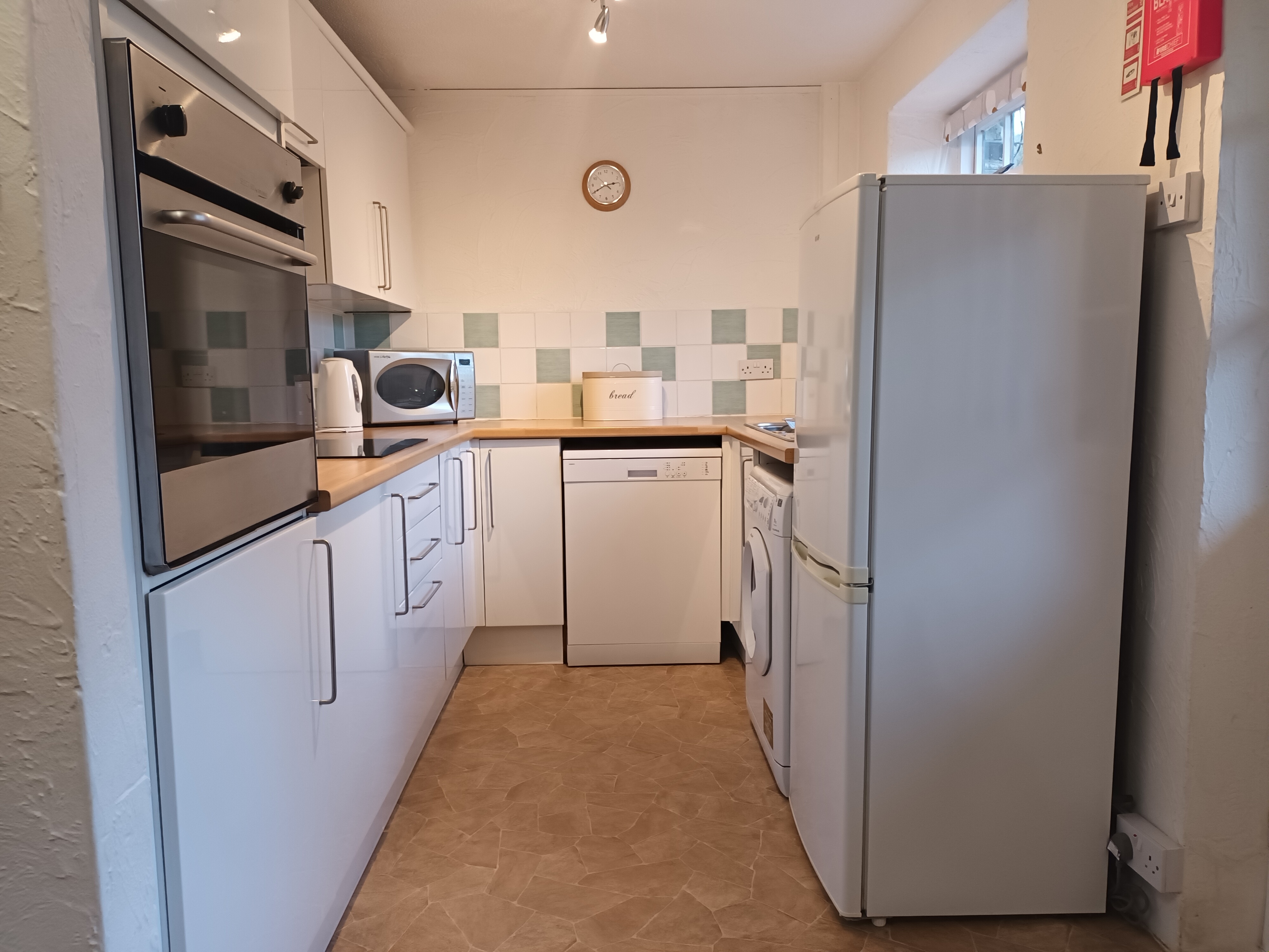 Light kitchen with fridge/freezer, oven, dishwasher and washer/dryer