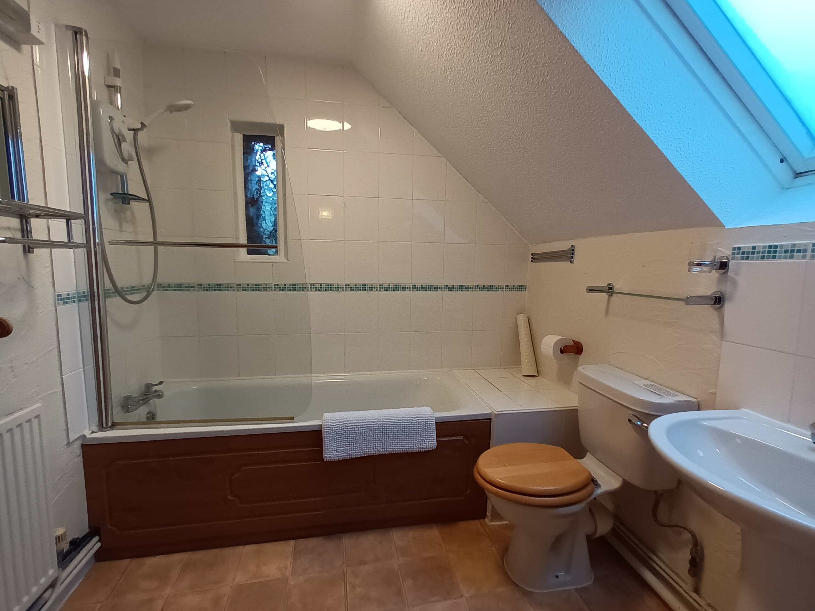 Family bathroom - toilet, sink and bath with shower over