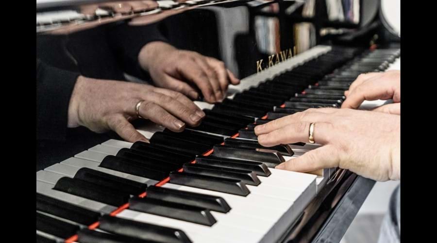 Hands playing the baby grand piano at the The Old Chapel Pentney dog friendly self catering holiday cottage in rural Norfolk.