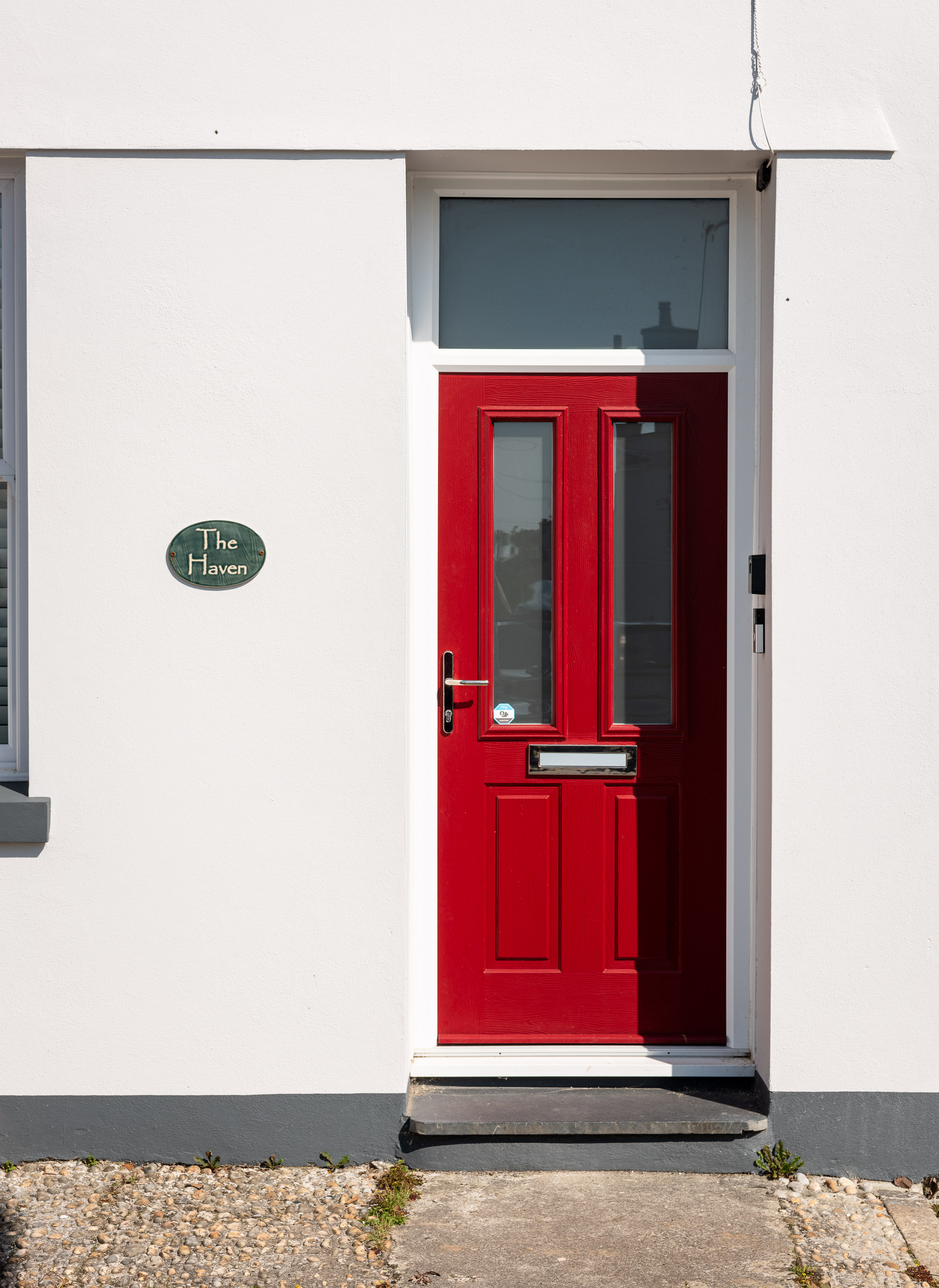 The grey house with a red door