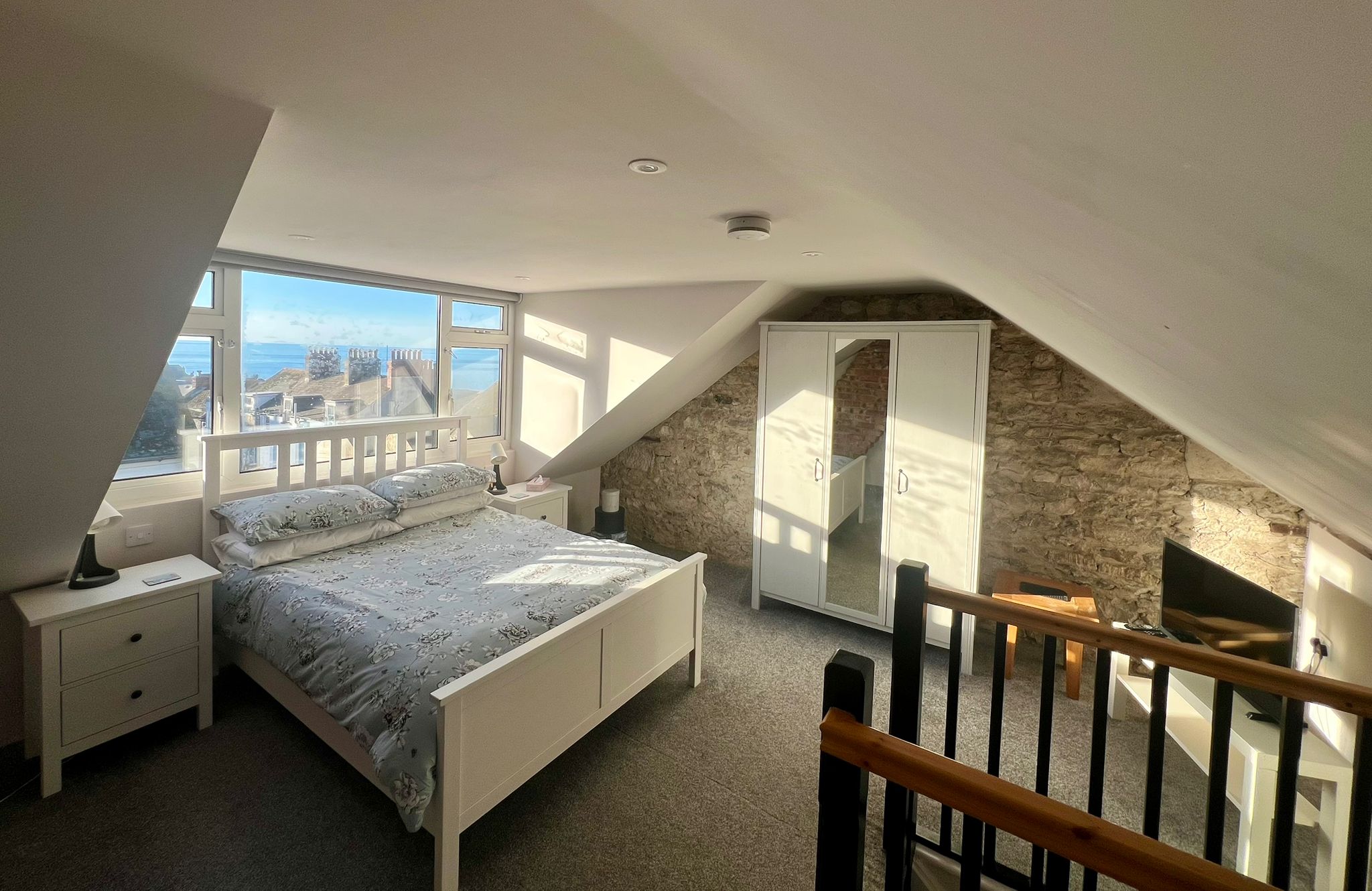 The loft bedroom, flooded with light and sea air