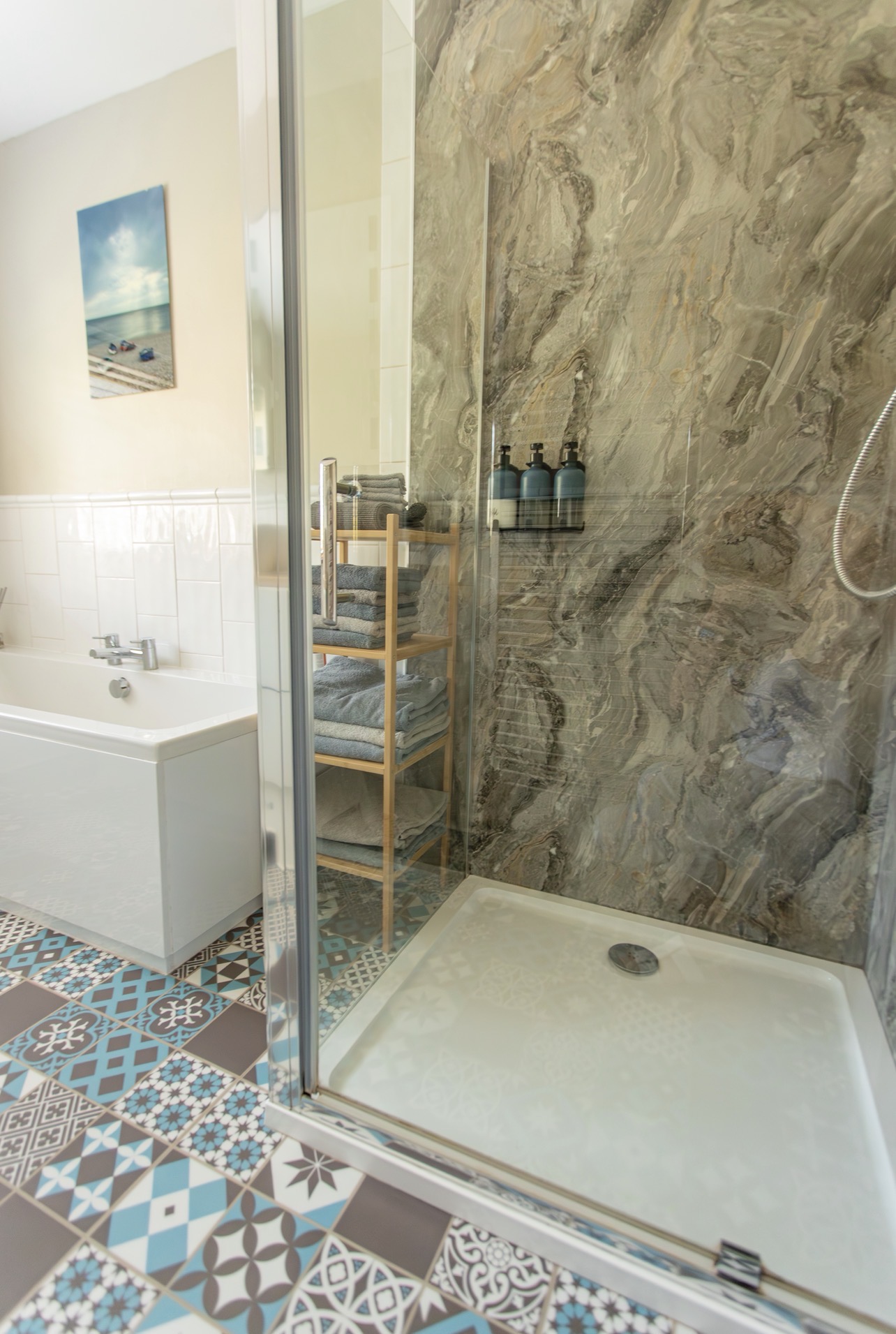 Walk-in rain shower with glass screen and stone-effect wall tiles