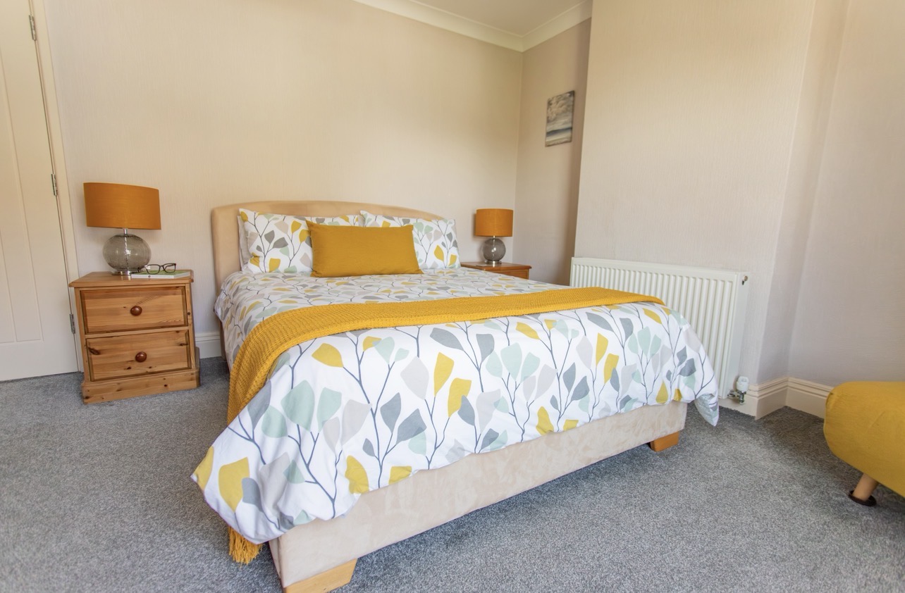Spacious king bedroom with double bed, bedside tables and wardrobe