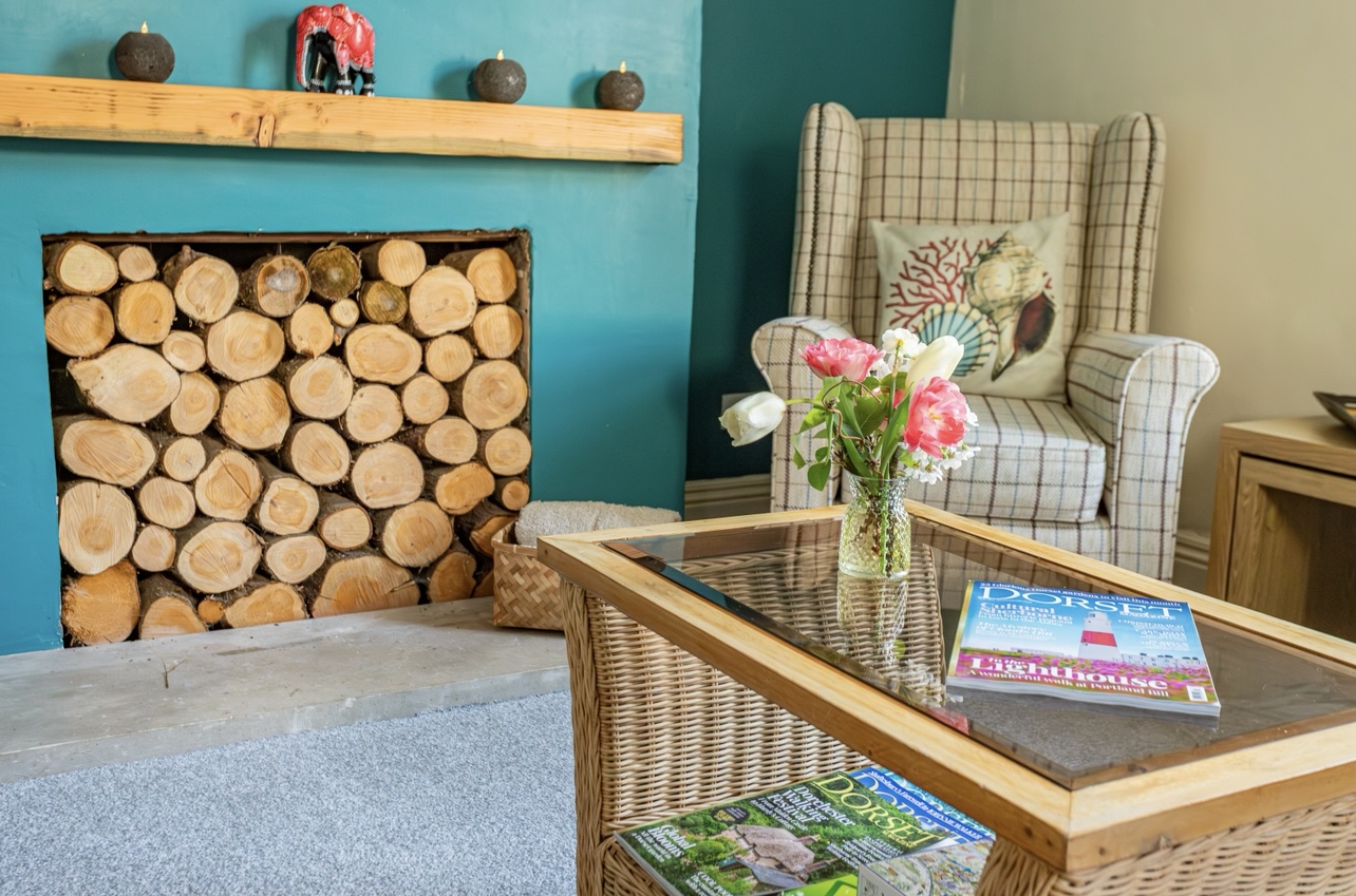 Feature fireplace and comfortable seating in Victorian coastal cottage.