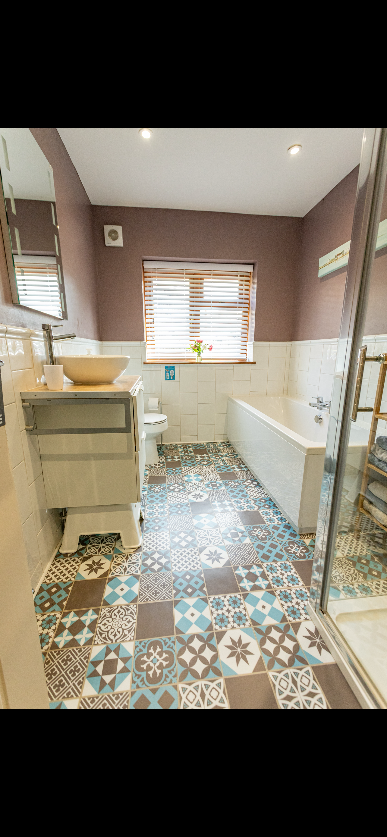 Bright family bathroom with bath, shower and soft towels provided