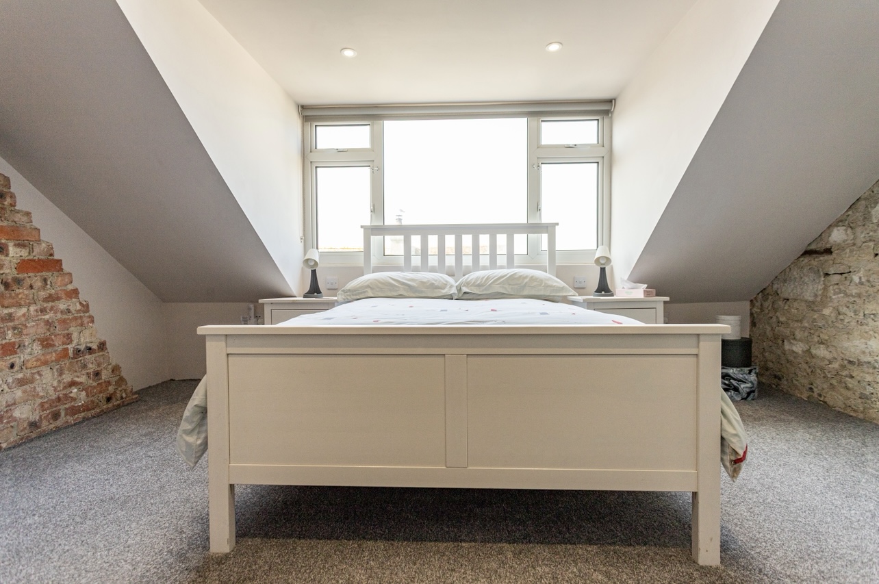 Spacious double bedroom with sea views from the loft in Portland holiday cottage.