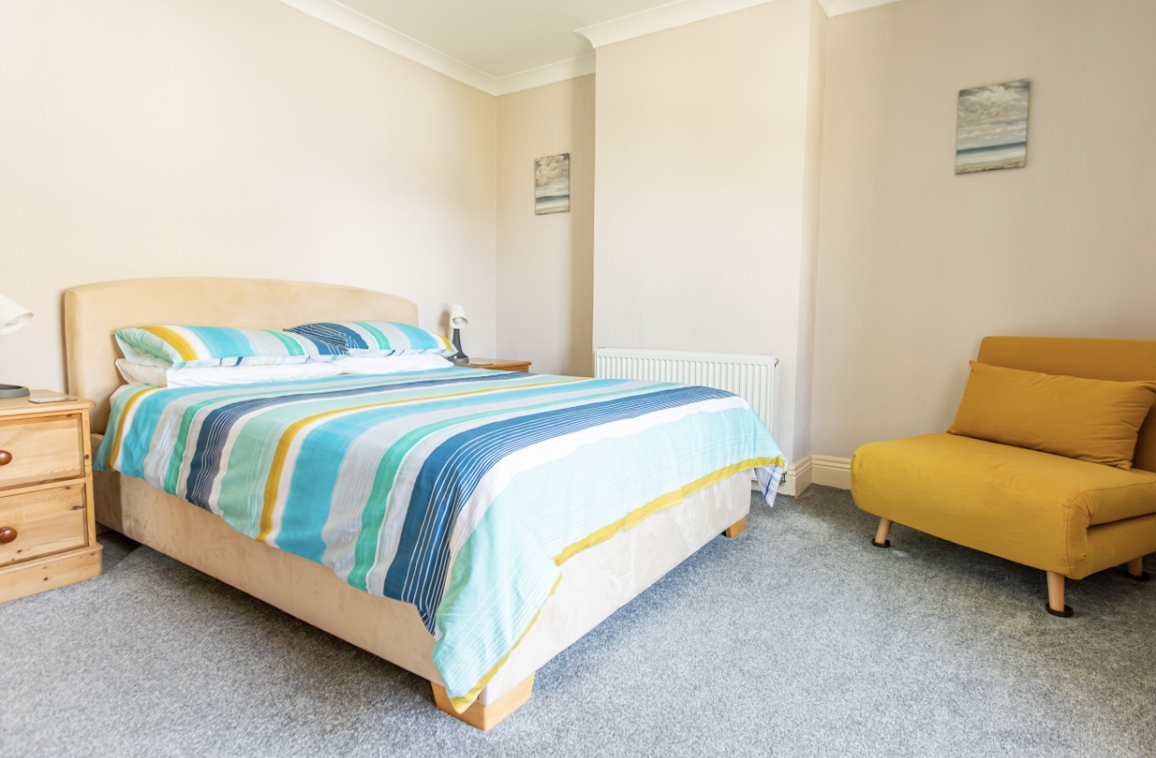 Spacious king bedroom with partial sea views in Portland holiday cottage