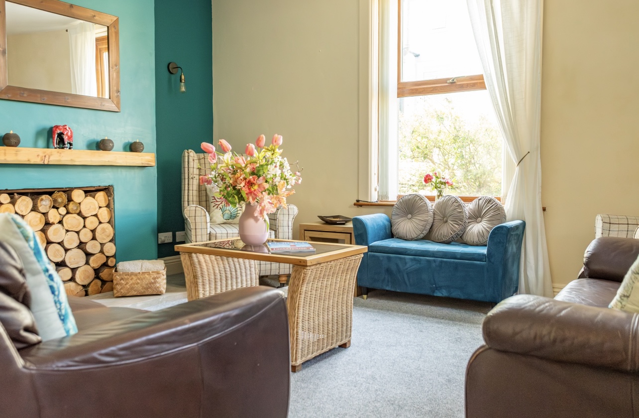 Cosy living room with board games and feature fireplace in Portland cottage