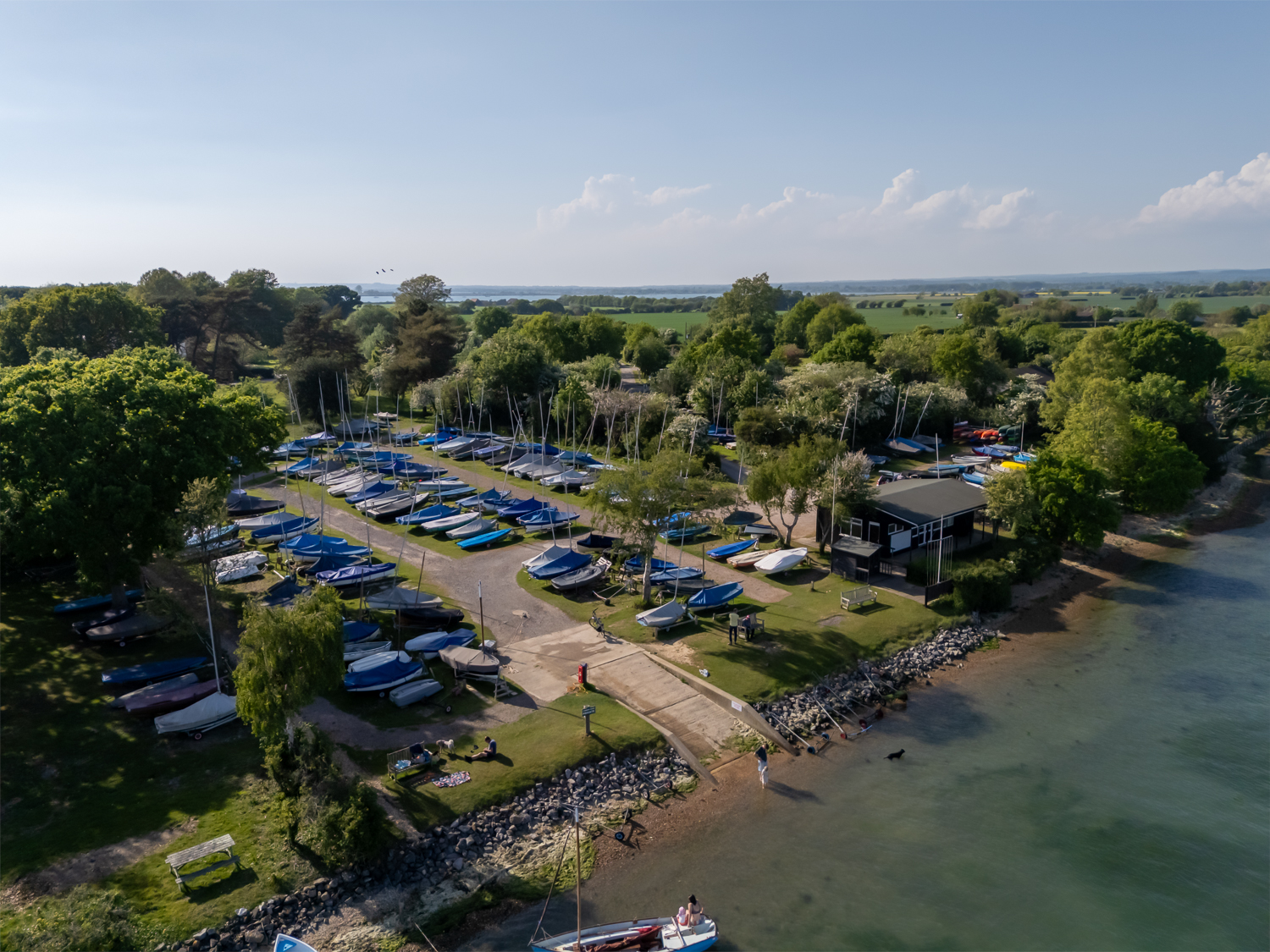 Aerial photo of the private dinghy park at Cobnor Estate, showing boats, kayaks and paddleboards stored near Chichester Harbour for guest use