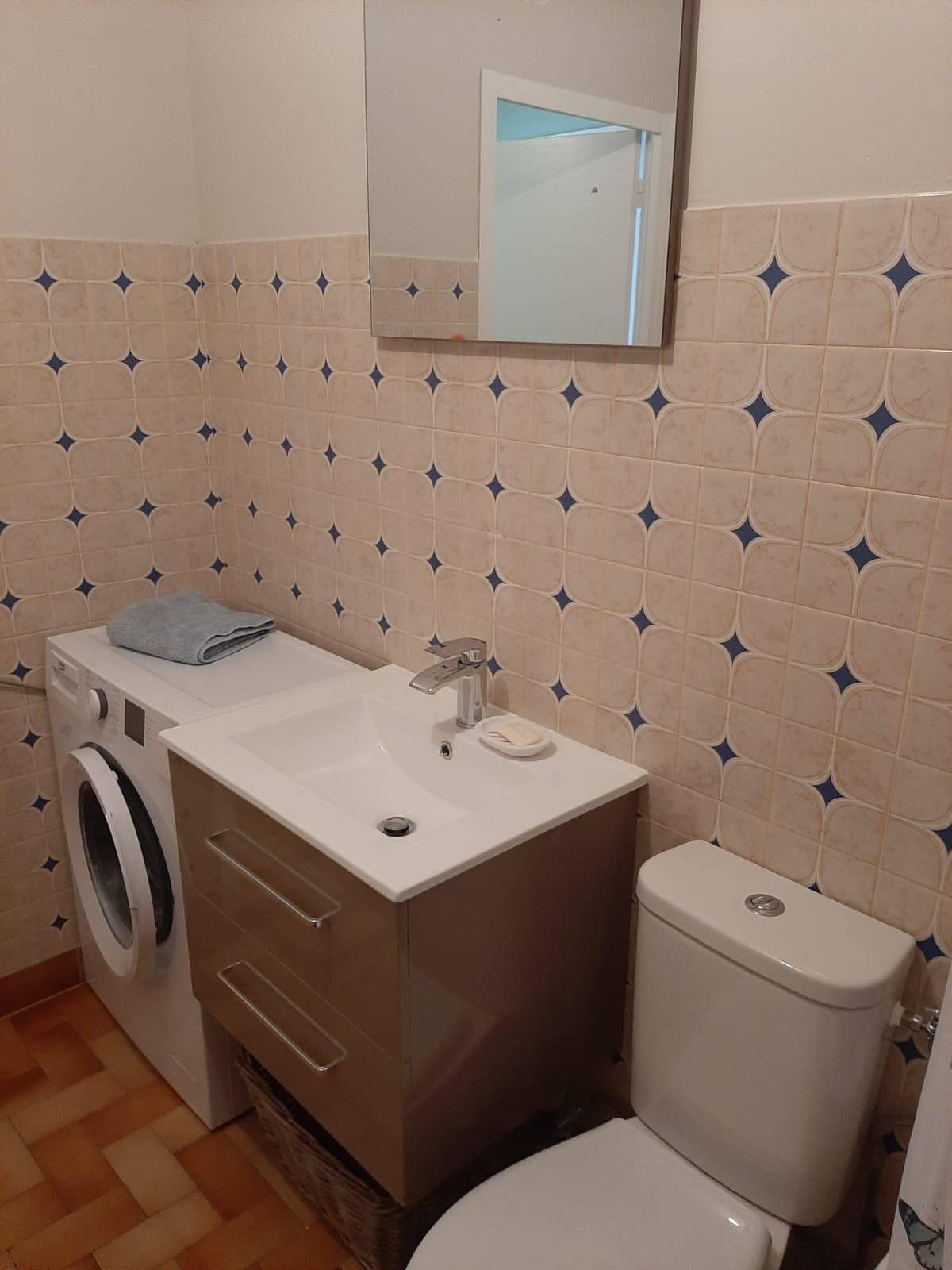Bathroom with bath and shower over and washing machine