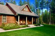 Front of house overlooking lush front lawn and trees.