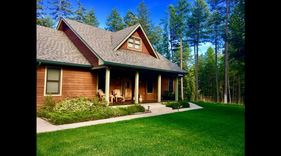 Front of house overlooking lush front lawn and trees.