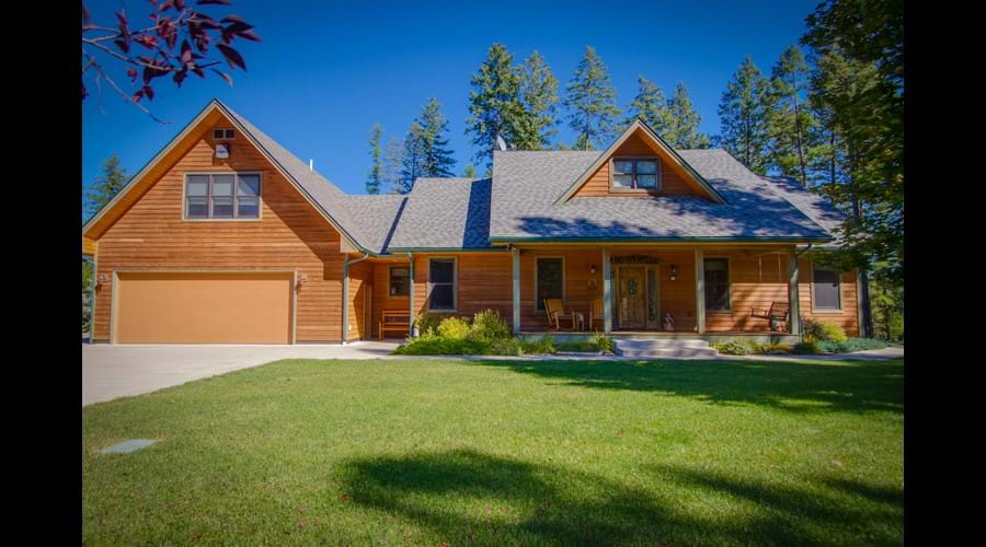 Lush lawn in front with lake views off the deck in back