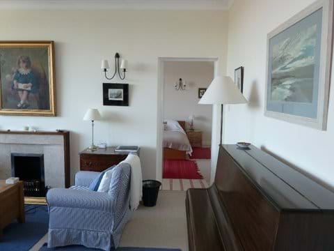 Looking from sitting room into bedroom. Upright piano.