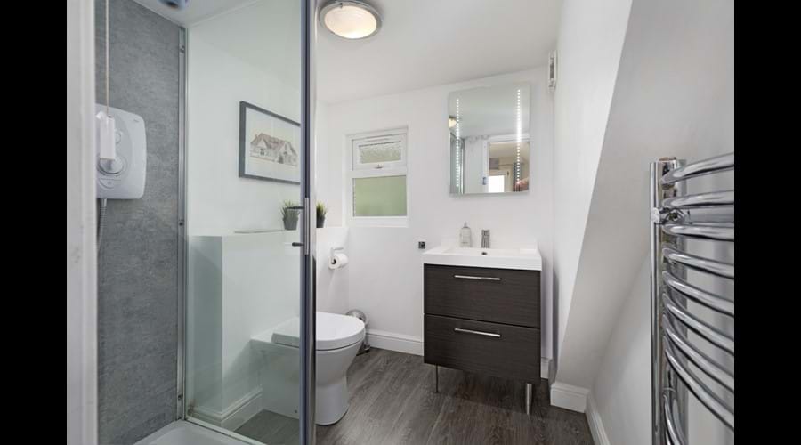 Ensuite to First Floor Double Bedroom with electric shower, wc, washbasin, shave point, demister mirror
