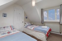 First floor twin room with bedside tables and small wardrobe/chest of drawers
