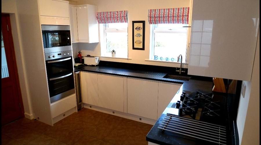 Newly fitted kitchen with fitted double oven, microwave, gas hob, dishwasher and fridge